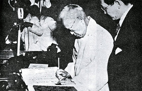 1948년 7월 17일 이승만 초대 국회의장의 제헌국회가 제정한 헌법에 서명하고 있다. [중앙포토]