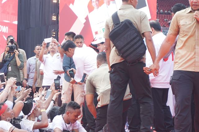 지난 4월 14일 자카르타의 겔로라 붕 카르노 스타디움에서 조코 위도도 대통령이 대선 유세를 마치고 지지자들의 휴대폰을 받아 인증 사진을 직접 찍어주는 모습.