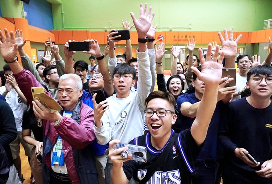 24일 열린 홍콩 구의회 선거의 개표 윤곽기 드러난 25일 아침 범민주파 후보들이 선전하자 지지자들이 환호하고 있다. [AP=연합뉴스]