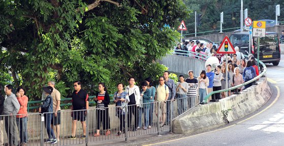 홍콩 구의원 선거가 진행된 24일 오전 홍콩 레이몬디 중학교에 마련된 투표소에서 시민들이 투표를 하기 위해 줄을 길게 서 있다. [뉴스1]