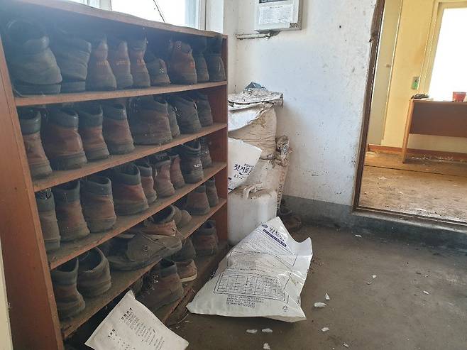 '금강농산' 숙소로 쓰이던 건물 내부에 있는 신발장에 먼지 묻은 작업화가 가득하다. 익산=김준희 기자