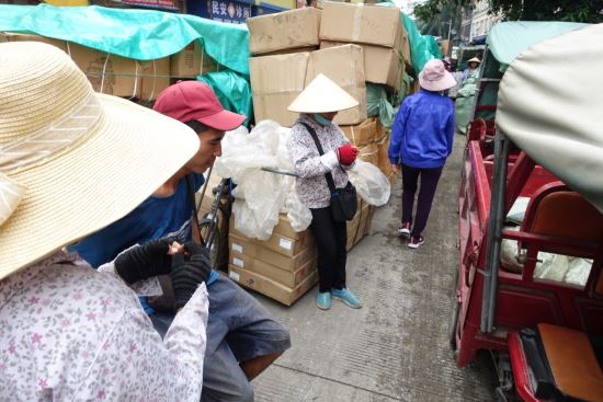 중국에서 베트남으로 넘어갈 통관 차례를 기다리고 있는 베트남 화물노동자들. 베트남의 대중국 수출품은 과일 등 대체로 농산품이어서 컨테이너 통관을 하는 반면,  중국에서 베트남으로 육로 국경을 통해 수입하는 물품들은 소형 가전제품이나 공구, 부품 등이어서 상대적으로 소규모 화물들이 많은 편이다. (중국 윈난云南성 허커우河口 촬영, 2019년 8월 3일)