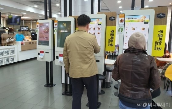 서울 종로구 한 패스트푸드점에서 소비자들이 키오스크를 이용해 주문하고 있다./사진=박가영 기자