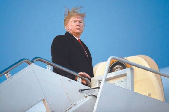 18일(현지시간) 미국 하원에서 탄핵소추안을 처리하던 시각, 도널드 트럼프 대통령이 미시간주에서 열리는 선거 유세를 위해 앤드루 공군기지에서 전용기에 오르고 있다. [AP=연합뉴스]