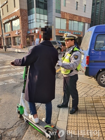 서울 수서경찰서가 26일 강남구 대치동 은마아파트 북문 사거리에서 진행한 '불법 오토바이 암행 단속'에서 전동 킥보드 운전자가 단속에 걸려 경찰의 주의를 받고 있다. / 사진=정경훈 기자