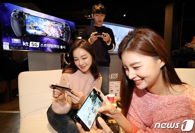지난해 12월 서울 성동구 카페봇에서 열린 KT '5G 스트리밍 게임 서비스' 공개 행사에서 모델들이 5G 스마트폰으로 서비스를 체험하고 있다. © 뉴스1