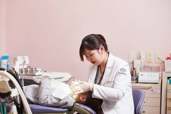 ◇한 해 구강질환자의 수가 2100만명에 달하는 것으로 나타났다. 특히 치주질환과 치아우식증은 잘못된 칫솔질과 부적합한 용품을 사용해 발생할 수 있어 주의가 필요하다. 사진은 강동경희대병원 소아치과 김미선 교수가 치주질환 환자를 진료하는 모습.