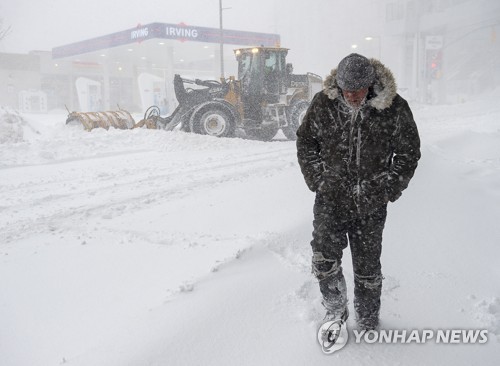 눈폭풍이 몰아친 세이튼존스 시가지를 걷는 한 보행자 [AP=연합뉴스 자료사진]