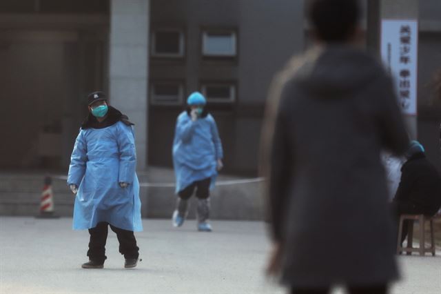 신종 코로나바이러스에 감염된 우한 폐렴 환자들이 치료를 받고 있는 중국 후베이성 우한의 진인탄 병원 앞에서 20일 마스크를 쓴 보안요원들이 경계를 서고 있다. 우한=로이터 연합뉴스