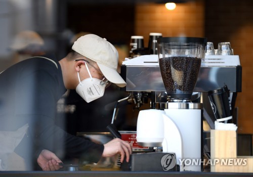 24일 베이징에서 카페 직원이 마스크를 쓴채 일하고 있다. [AFP=연합뉴스]