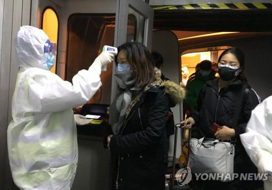 지난 22일(현지시간) 중국 우한에서 온 승객들을 대상으로 한 베이징 공항 당국의 체온 검사 / 사진=연합뉴스