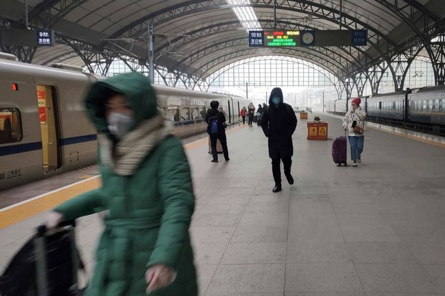 중국 우한에서 지난 23일 봉쇄령이 내려지기 직전 몇몇 사람들이 기차역 플랫폼에서 마스크를 쓴 채 걸어가고 있다.ⓒAP/뉴시스
