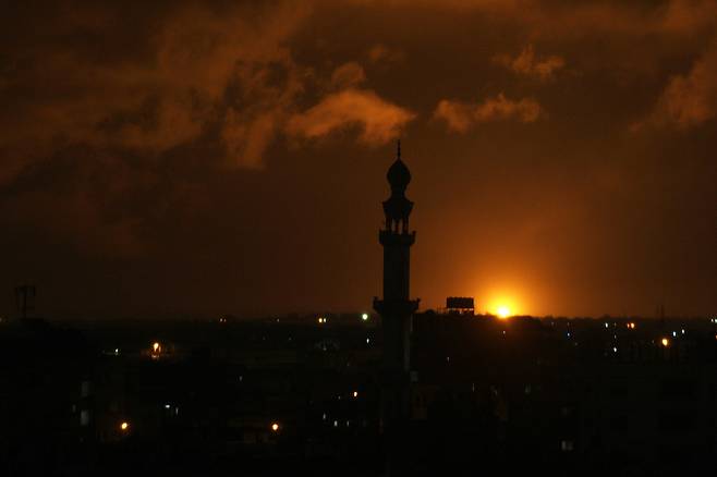 지난 10일 새벽(현지시각) 이스라엘 공군이 공습을 단행한 팔레스타인 가자 지구 남부의 칸 유니스에서 폭탄이 터지며 붉은 화염 불빛이 퍼지고 있다. 칸 유니스/UPI 연합뉴스