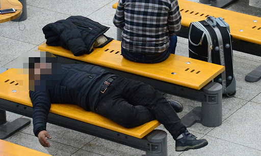 지난 12일 인천국제공항에서 한 노숙인이 의자에 누워 잠을 자고 있다.