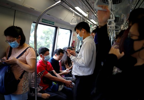 18일(현지시간) 81명의 확진자가 나온 싱가포르의 전철 안에서 출근하는 시민들이 대부분 마스크를 쓰고 있다. [로이터=연합뉴스]