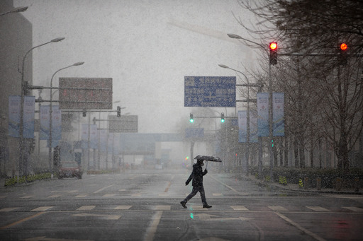 중국의 수도 베이징에서 지난 14일(현지시간) 마스크를 쓴 한 남성이 신종 코로나바이러스 감염증(코로나19)에 대한 불안감으로 인적이 끊긴 교차로를 건너고 있다. 베이징=AP연합뉴스