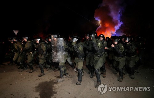 코로나19의 발병지인 우한에서 데려온 이들을 이송하기 위해 주민들의 봉쇄를 뚫고 있는 우크라이나 경찰들[로이터=연합뉴스]