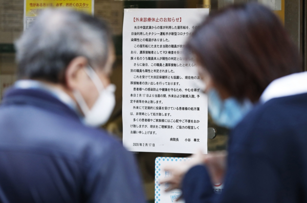 직원이 신종 코로나바이러스 감염증(코로나19)에 걸린 것으로 확인된 일본 도쿄도(東京都)의 한 병원에 17일 오후 외래 진료 중단을 알리는 안내문이 붙어 있다. /교도연합뉴스