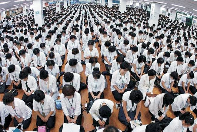 신천지 대구교회 집회 장면. 신도들이 동일한 색상의 옷을 입고 마루 바닥에 앉아 기도를 하고 있다. 신천지 자료집