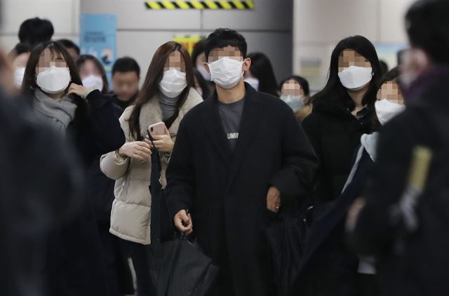 신종 코로나바이러스 감염증 여파로 마스크를 착용한 시민들이 지난 25일 출근시간 서울 여의도 국회의사당역을 나서고 있다. 연합뉴스