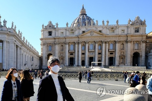 마스크를 쓰고 바티칸 성베드로 성당 앞을 지나는 관광객들. 2020.2.28. [AFP=연합뉴스]