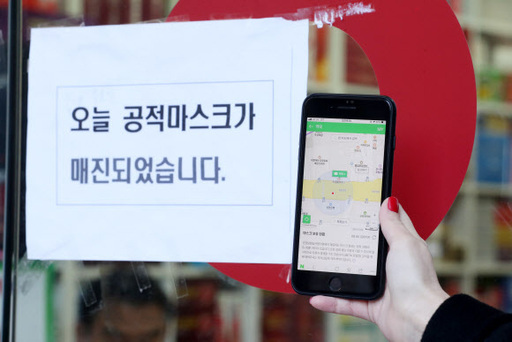 마스크 현황 앱 서비스가 시작된 11일 오전 서울 광화문의 한 약국 앞에서 시민이 앱을 통해 마스크 충분 상태를 확인한 뒤 방문했으나 마스크 품절 안내문이 붙어 있다.