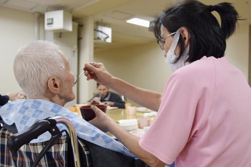 (도쿄 교도=연합뉴스) 2020년 1월 30일 일본 도쿄도(東京都)의 한 노인복지시설에서 직원이 고령자의 식사를 돕고 있다. 2020.3.12