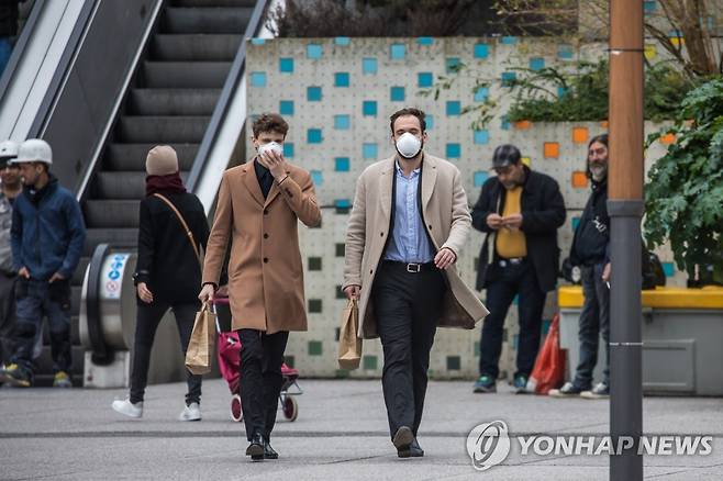 16일 프랑스 파리 국제업무지구인 라 데팡스에서 직장인들이 마스크를 쓴 채 걸어가는 모습. [EPA=연합뉴스]