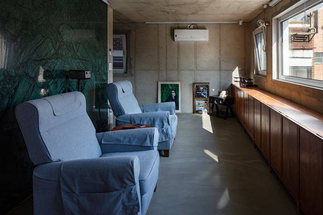 2층은 영화관 같은 거실이다. 긴 창을 통해 풍경을 감상할 수도 있지만 창 앞에 큰 스크린을 내려 영화를 감상할 수 있다. 청록색 대리석을 거실 벽에 부착해 남성적인 공간으로 연출했다. ©진효숙 건축사진작가