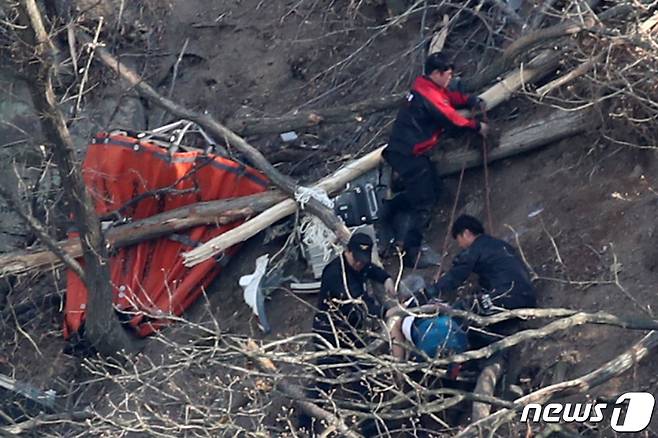 19일 오후 3시께 울산 울주군에서 산불 직화작업을 벌이던 기장과 부기장 등 2명이 탑승한 소방헬기 1대가 옛 통천마을 뒷편 회야댐에 추락한 가운데 헬기 밤비 버킷(Bambi bucket, 헬기에 줄을 매달아 쓰는 물통) 옆으로 소방대원들이 기장 1명을 구조하고 있다. 2020.3.19/뉴스1 © News1 윤일지 기자