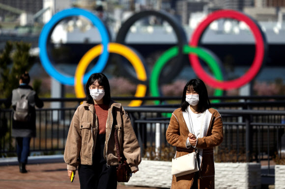 코로나19 도쿄 올림픽 오륜 앞 마스크 쓴 시민들 - 마스크를 쓴 일본 도쿄 시민들이 신종 코로나바이러스 감염증(코로나19) 발생 이후 2020 올림픽이 열리는 오다이바 해변공원의 오륜 조형물 앞을 27일 지나고 있다.도쿄 로이터 연합뉴스