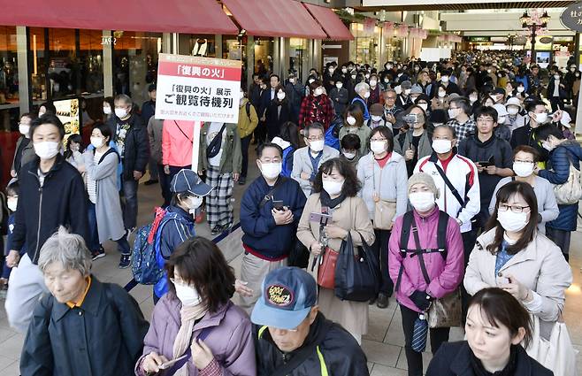 세계보건기구(WHO)의 자제 당부에도 불구하고 올림픽 성화에 마스크도 끼지 않은 사람이 다수 포함된채 다중 운집한 일본 국민들. [로이터 연합]