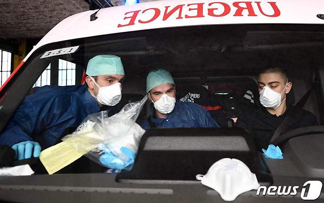 프랑스 긴급 구조 대원들이 마스크와 방호복을 착용한 채 응급차량에 앉아 있다. © AFP=뉴스1