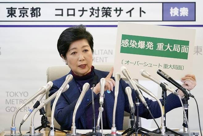 고이케 유리코 일본 도쿄도지사가 25일 저녁 긴급 기자회견을 열어 “감염 폭발 중대 국면”이라고 쓴 팻말을 들어 보이고 있다. 도쿄/EPA 연합뉴스