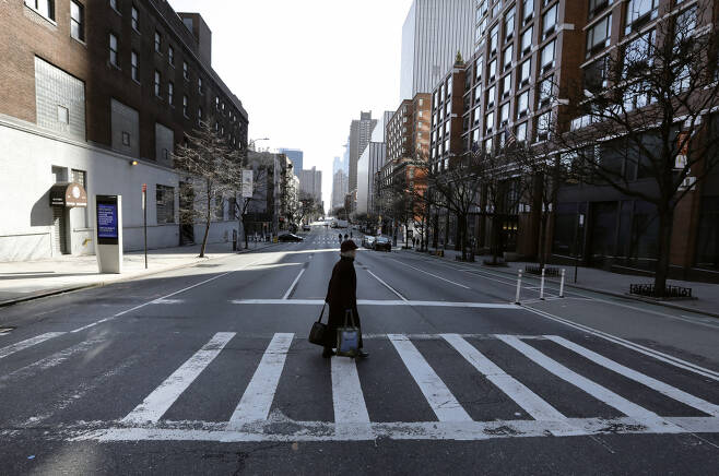한 여성이 24일(현지시간) 텅빈 뉴욕 거리를 걷고 있다. [EPA]