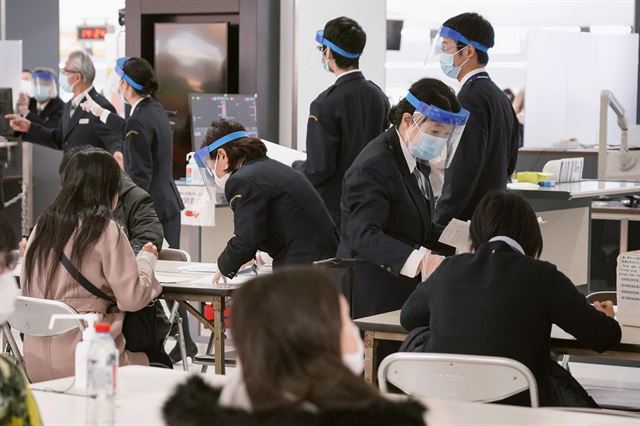 지난 21일 도쿄의 관문인 지바현 나리타국제공항 검역요원들이 입국자들을 대상으로 신종 코로나바이러스 감염증 확산에 따른 강화된 검역 조치에 대해 설명하고 있다. 지바=AP 연합뉴스