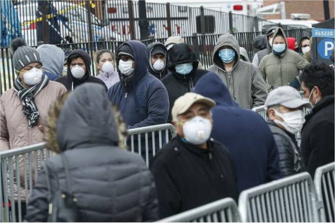 25일(현지시간) 미국 뉴욕 퀸스의 엘름허스트 병원 입구에서 시민들이 마스크를 쓴 채 신종 코로나바이러스 감염증(코로나19) 검사를 받기 위해 줄을 서서 차례를 기다리고 있다. (사진=연합뉴스)
