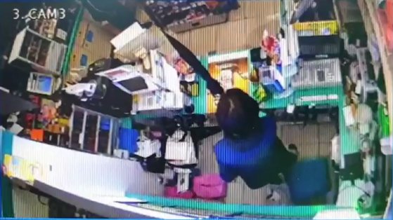 편의점에서 근무 중이던 김모(50·여)씨가 A씨가 편의점에 들어온 것을 확인하고 놀라 우산을 든 모습. 편의점 CCTV영상 캡쳐