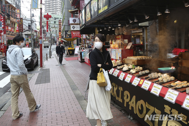 [요코하마=AP/뉴시스]지난달 31일 신종 코로나바이러스 감염증(코로나19) 확산을 막기 위해 마스크를 쓴 한 여성이 일본 도쿄 인근 요코하마의 차이나타운 상가에서 음식을 기다리고 있다. 2020.03.31.