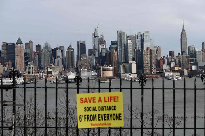 미국 뉴욕주의 한 공원 난간에 2일(현지시간) 맨해튼 스카이라인을 배경으로 코로나19 확산 방지를 위한 사회적 거리두기 촉구 메시지가 걸려 있다. (사진=AFP/연합뉴스 제공)