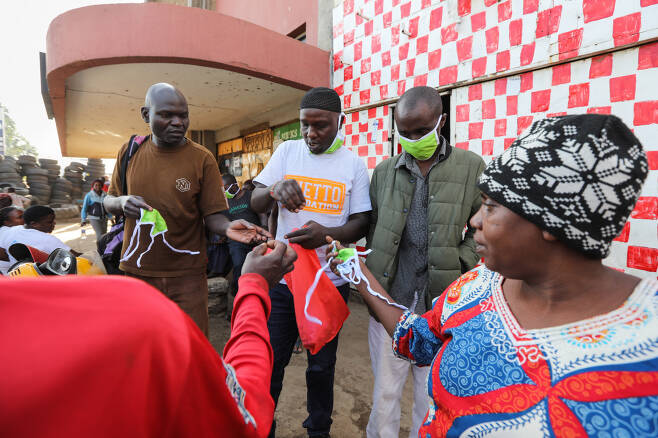 케냐 나이로비 빈민촌에서 8일(현지시간) 비정부기구(NGO) 게토파운데이션이 주민들에게 마스크를 나눠주고 있다.   나이로비｜EPA연합뉴스