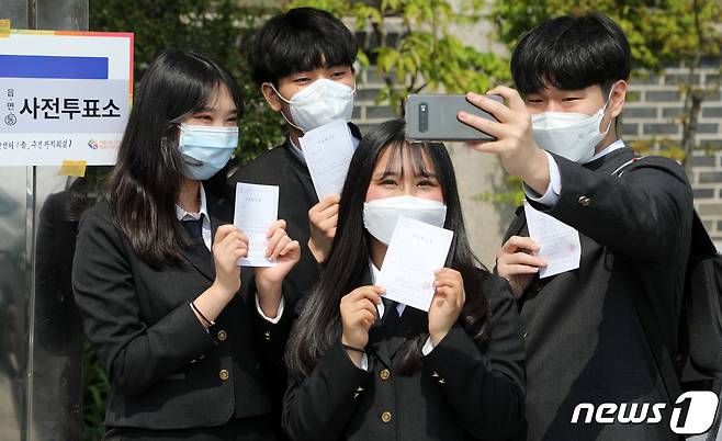 제21대 국회의원 선거 사전 투표 첫날인 10일 오후 경기도 수원시 팔달구 행궁동 행정복지센터에 마련된 사전투표소에서 첫 투표를 마친 삼일공업고등학교 3학년인 만 18세 학생유권자들이 투표확인증을 들고 인증샷을 남기고 있다. 2020.4.10/뉴스1 © News1 조태형 기자