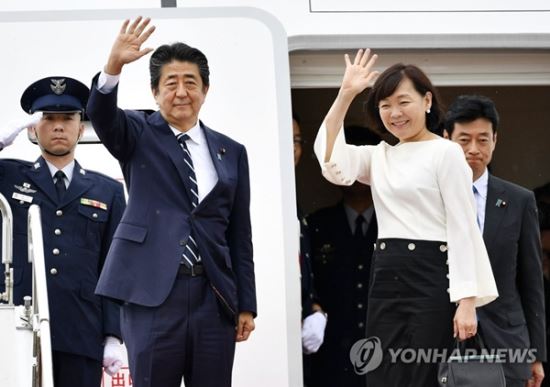 아베 신조 일본 총리가 지난해 8월 23일 부인 아키에(오른쪽) 여사와 함께 프랑스에서 열리는 선진 7개국(G7) 정상회의 참석을 위해 전용기편으로 하네다공항에서 출국하기에 앞서 손을 들어 인사하고 있다. 교도통신 연합뉴스