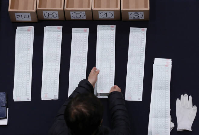 15일 오후 서울 종로구 경복고등학교에 마련된 투표소에서 개표요원들이 비례대표 투표용지를 수개표하고 있다. [연합]