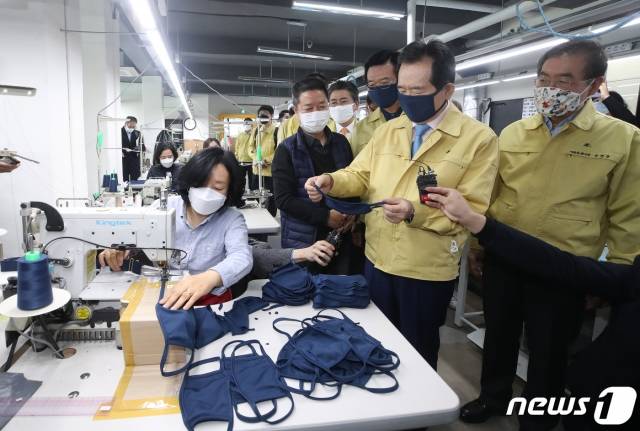 (서울=뉴스1) 이동해 기자 = 정세균 국무총리가 박원순(오른쪽) 서울시장과 함께 25일 오전 서울 용산구 만리시장 내 한국패션봉제협회 교육장인 코워킹팩토리를 찾아 필터교체형 면마스크인 '서울형 마스크' 생산 현장을 둘러보고 있다. 오른쪽 세번째는 이상태 한국패션봉제협회장. 2020.3.25/뉴스1