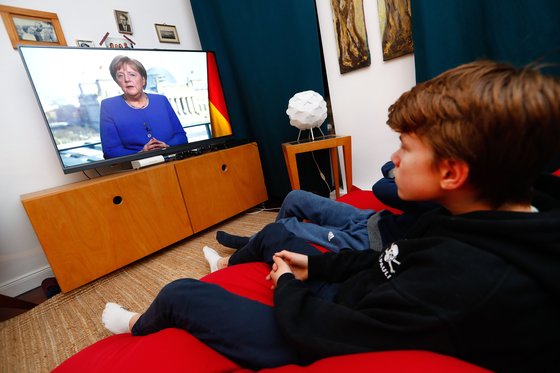 3월 18일 앙겔라 메르켈 독일 총리가 TV를 통해 대국민 연설을 하는 것을 시청자들이 지켜보고 있다. [로이터=연합뉴스]