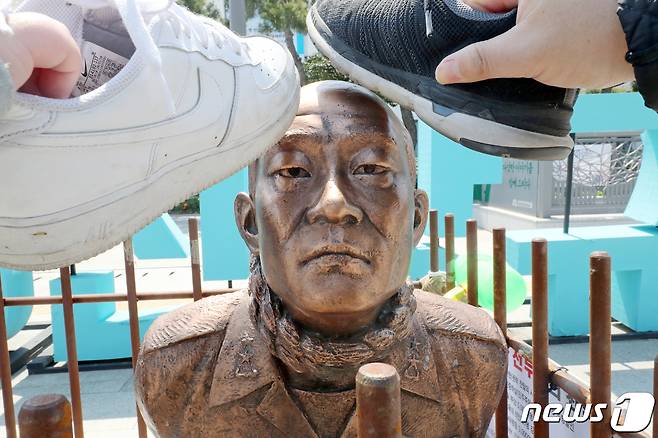 26일 오전 광주 동구 5·18민주광장에서 시민들이 '무릎꿇은 전두환 동상'을 신발로 내리치는 퍼포먼스를 하고 있다.2020.4.26/뉴스1 © News1 허단비 기자