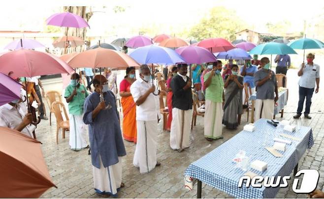 우산을 받아 쓴 인도 탄네르무콤 주민들 (사진 PS 죠티 탄네르무콤 촌장) © 뉴스1