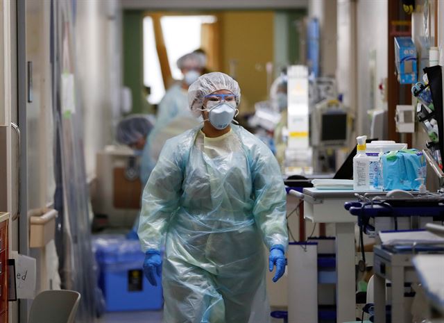 4일 일본 가나가와현 가와사키시의 한 대학병원에서 전신 방호복과 마스크를 착용한 의료진이 코로나19 환자를 치료하기 위해 이동하고 있다. 가와사키=로이터 연합뉴스