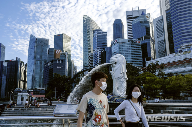 [싱가포르=AP/뉴시스]지난 3월14일(현지시간) 마스크를 낀 사람들이 싱가포르 머라이언 동상 앞을 지나가고 있다. 2020.05.15.